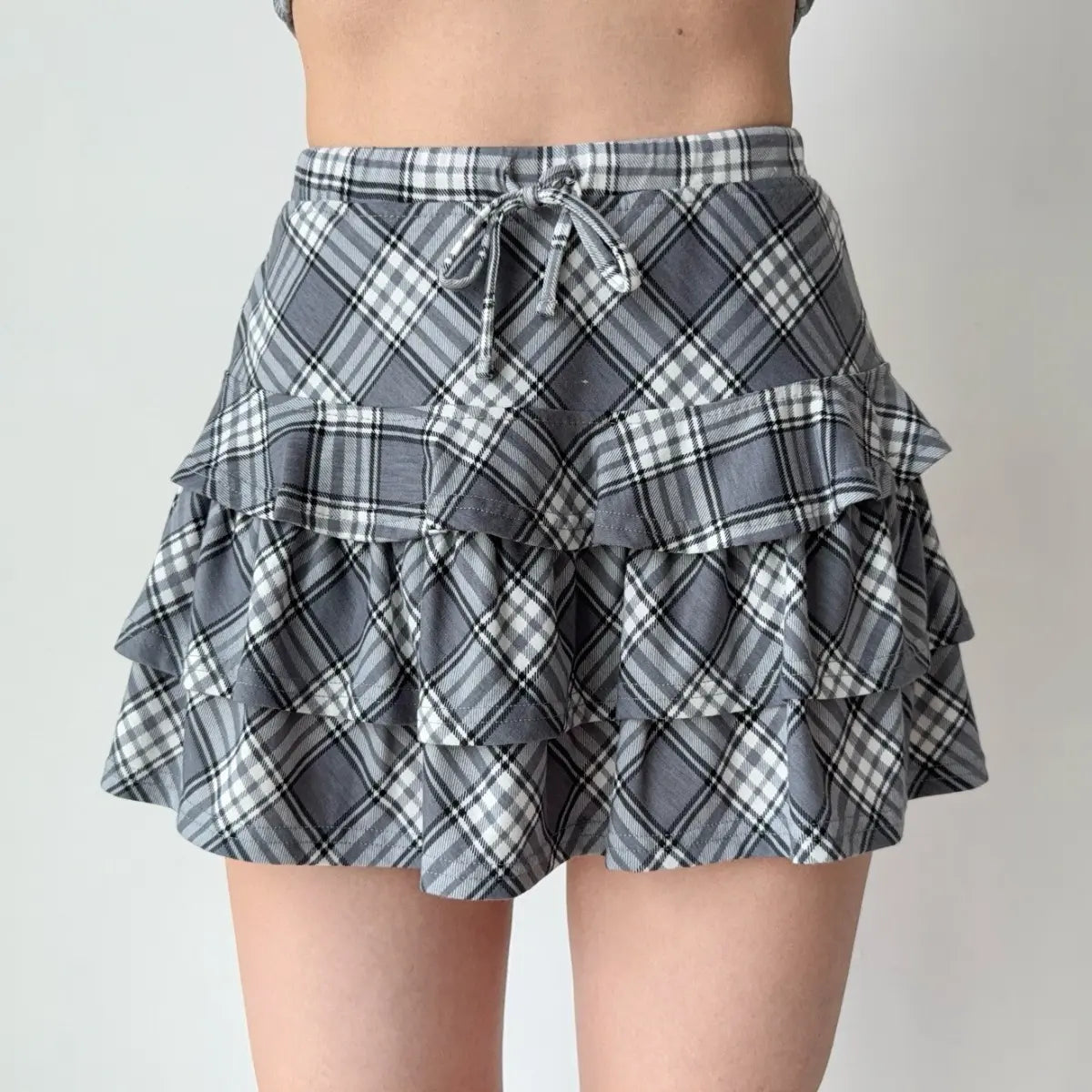 Gray and white plaid tiered ruffle mini skirt with a drawstring waist.