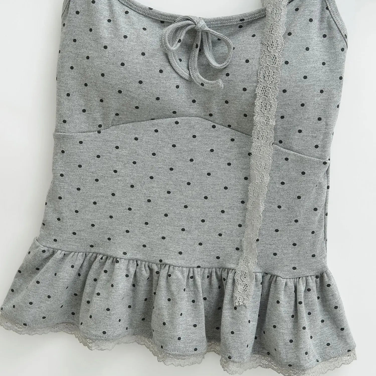 Heather gray black polka dot bow knit cami full front flat lay, bust tie bow thin straps lace peplum hem fitted cropped silhouette white background shot