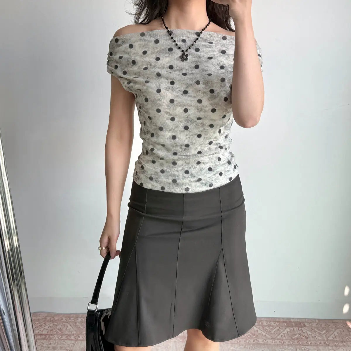 The outfit with the addition of a black handbag, showing the full look.