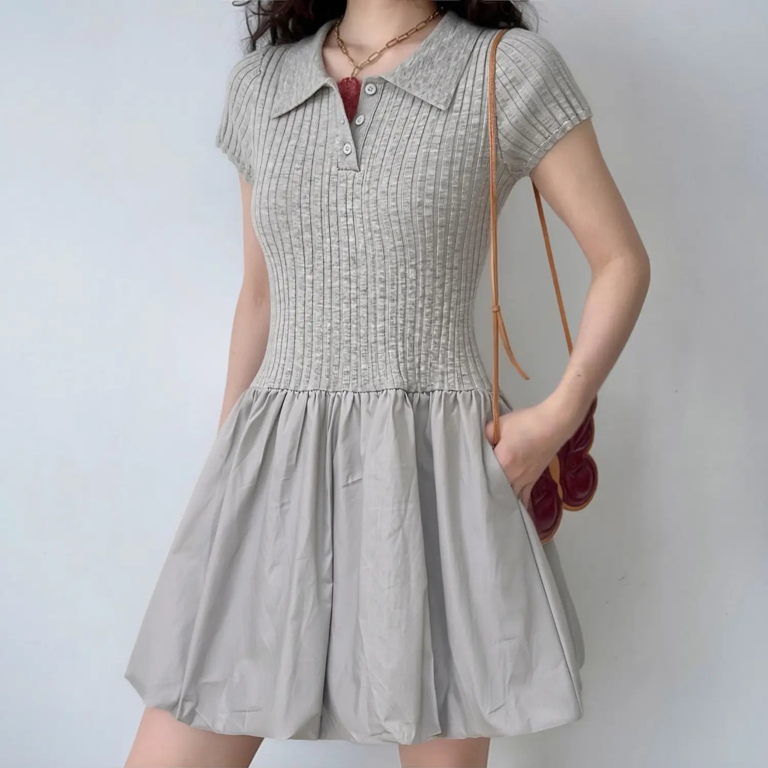 Lifestyle shot of model wearing the gray polo knit dress, showing the form-fitting bodice and puffy skirt