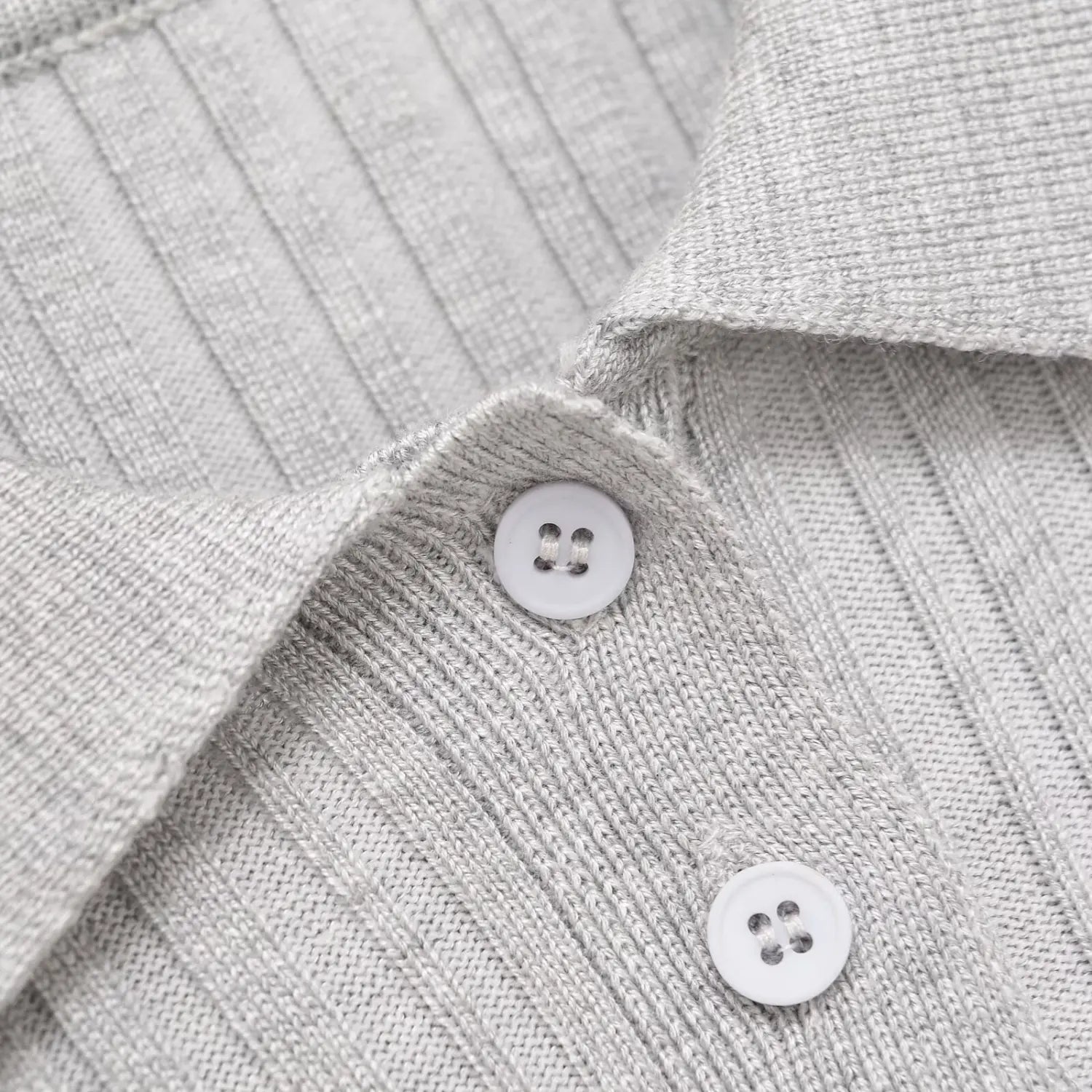  Close-up of the three white buttons on the polo placket of the gray knit dress