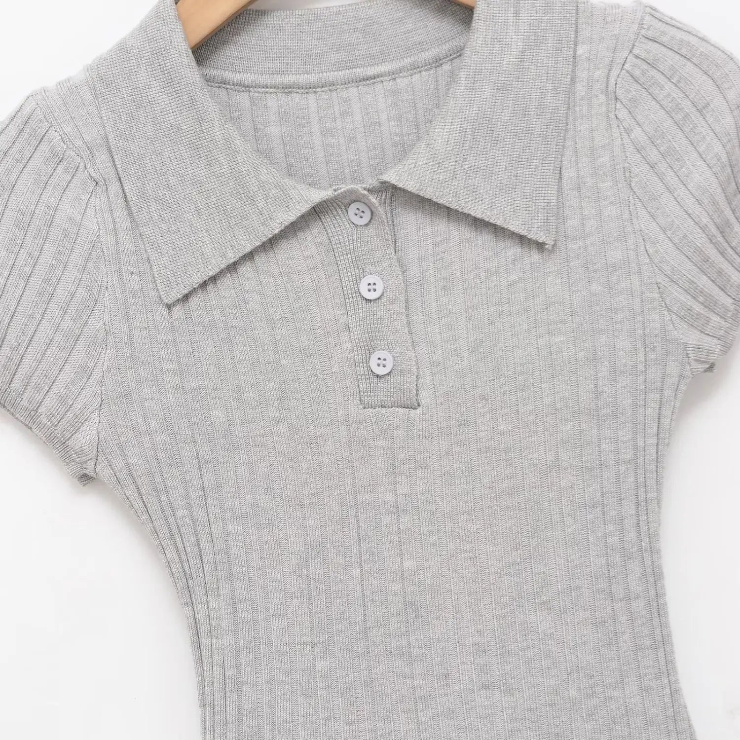 Close-up of the three white buttons on the polo placket of the gray knit dress