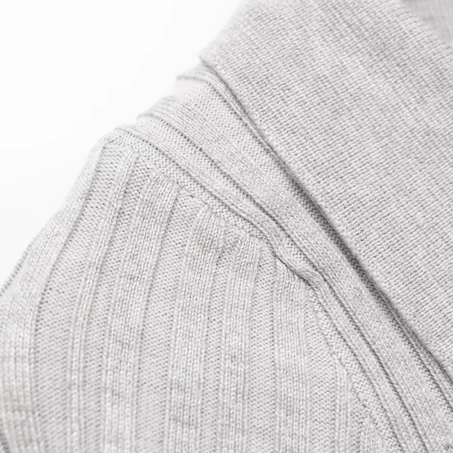 Close-up of the ribbed knit texture at the shoulder and sleeve seam on the gray dress