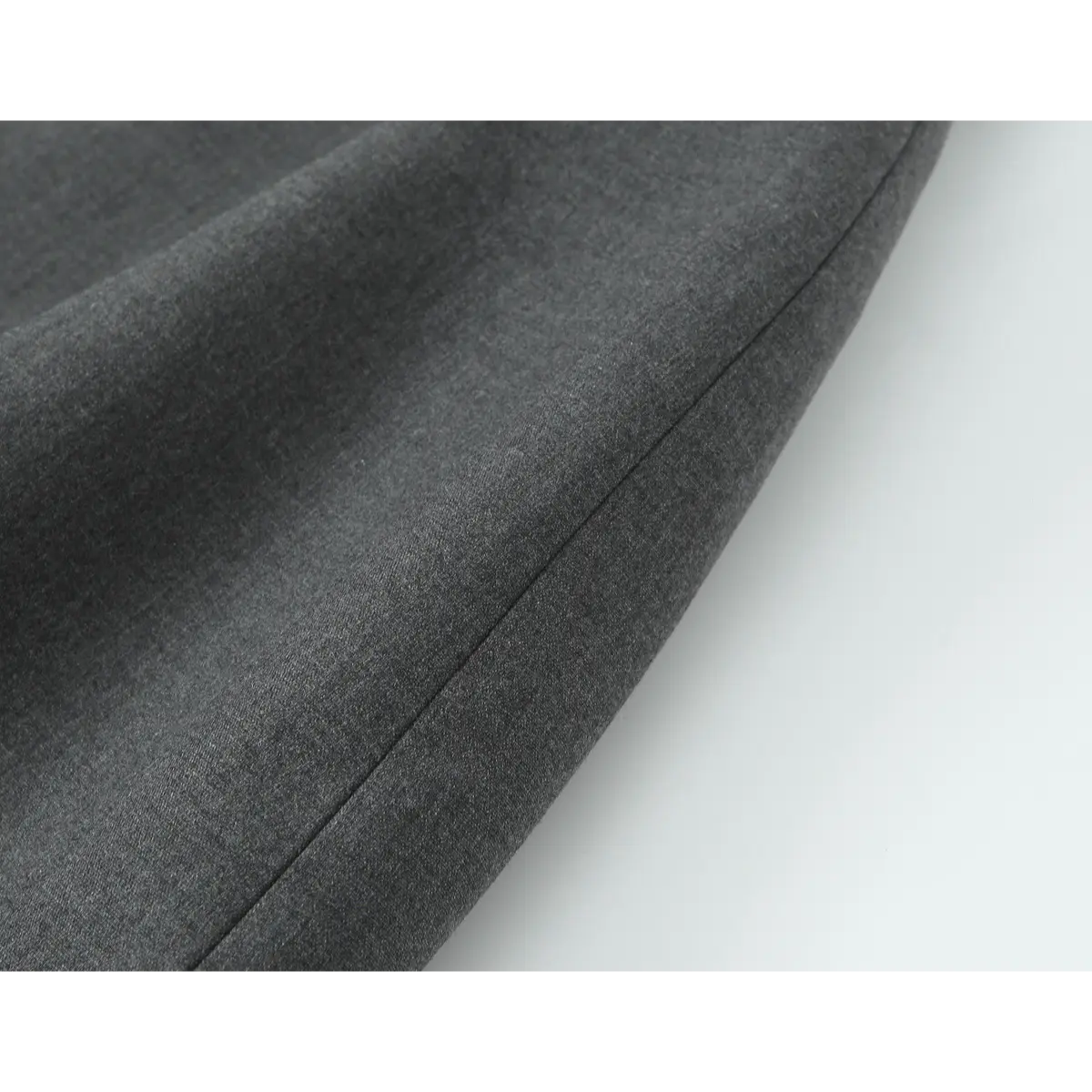 Close-up of the dress's fabric, showing the smooth texture of the suiting material.
