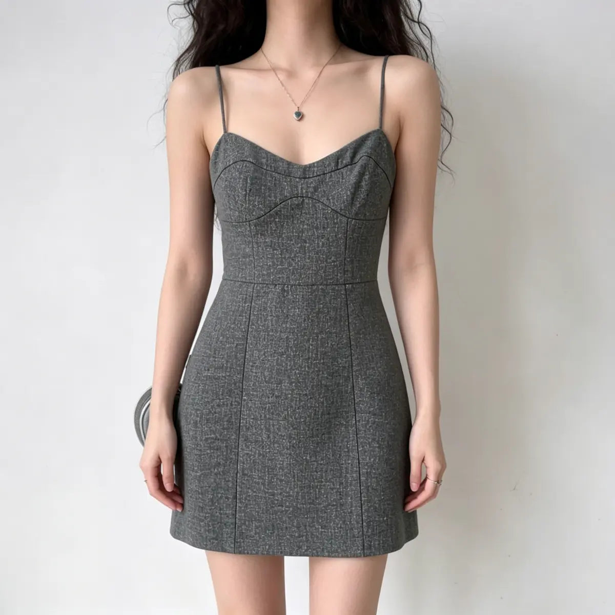 Model wearing a gray textured camisole dress with a sweetheart neckline, thin straps, and corset-style seams.
