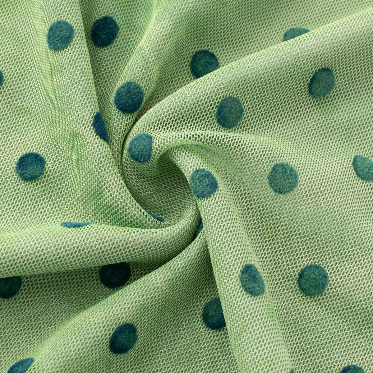 Close-up of the green polka dot mesh fabric, showing texture and pattern details.