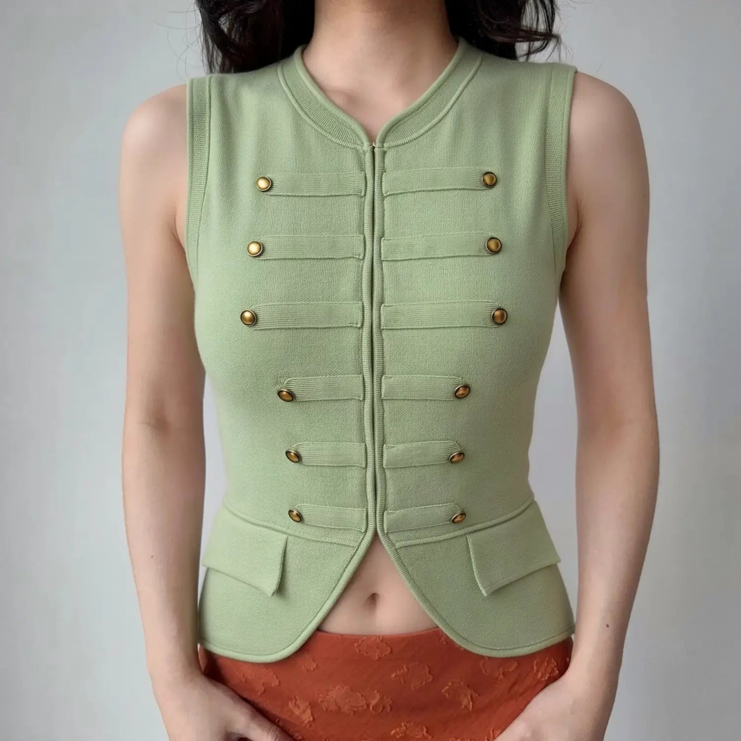 Model lifestyle shot wearing sage green double‑breasted tailored knit sleeveless waistcoat vest