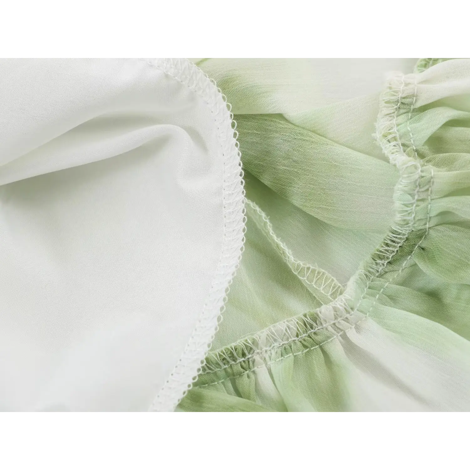 Close‑up view of inner lining fabric and overlock seam stitching on green floral chiffon maxi dress