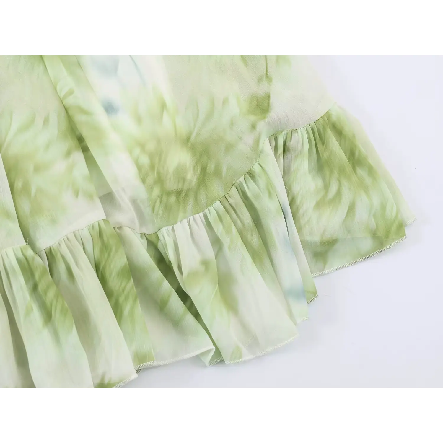 Close‑up of gathered ruffle hem and fine edge stitching for green floral chiffon maxi dress