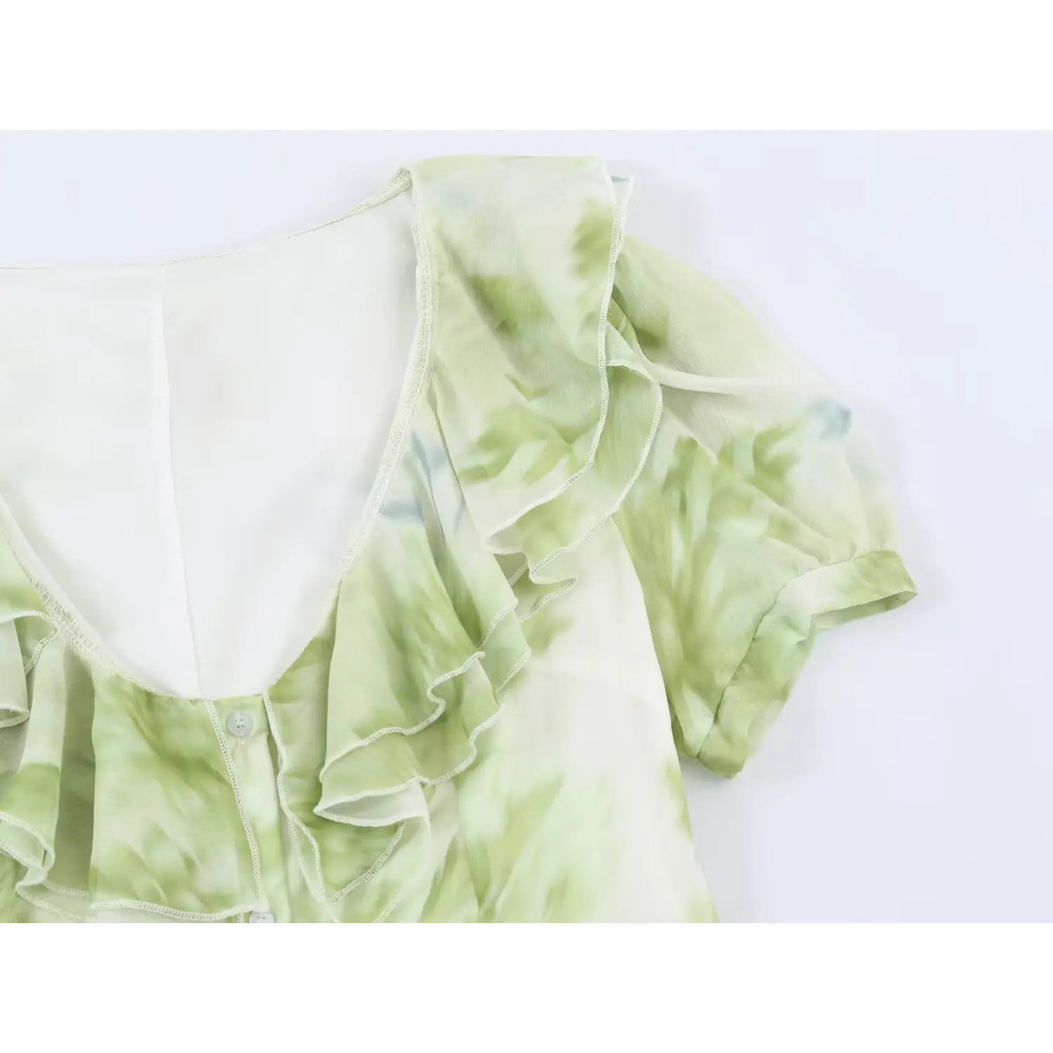 Partial close‑up of layered ruffle neckline and puff short sleeve on green floral chiffon maxi dress