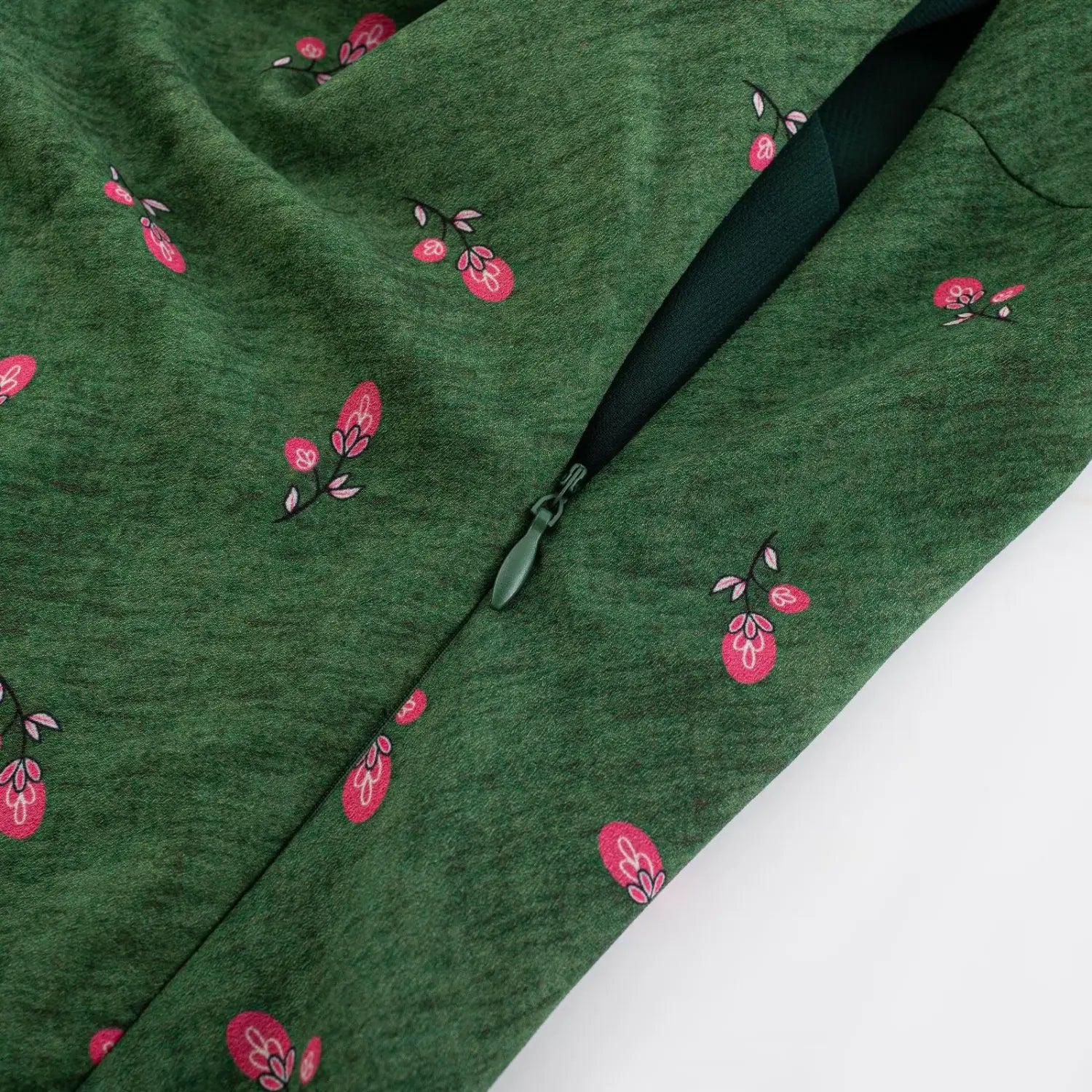 Side seam partial close-up hidden invisible zipper, matching dark green smooth full lining, printed outer fabric neat stitching edge