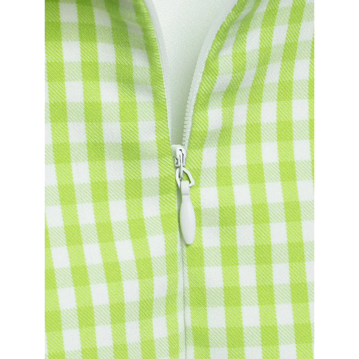 Close-up of the back zipper on a green gingham halter dress, showing the zipper pull and teeth.