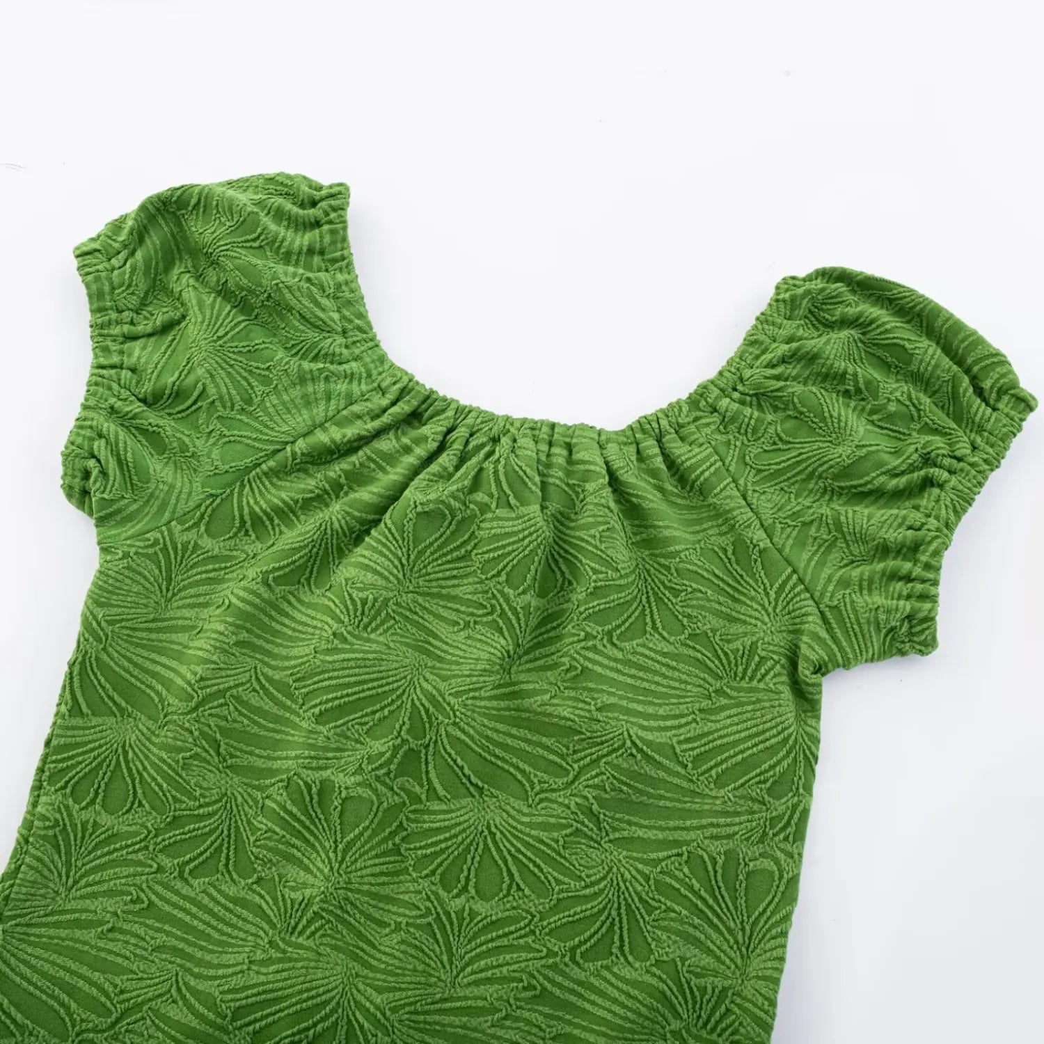 Top-down flat partial shot of green embossed ginkgo knit dress, elastic ruched square neckline and gathered bubble short sleeve cuffs