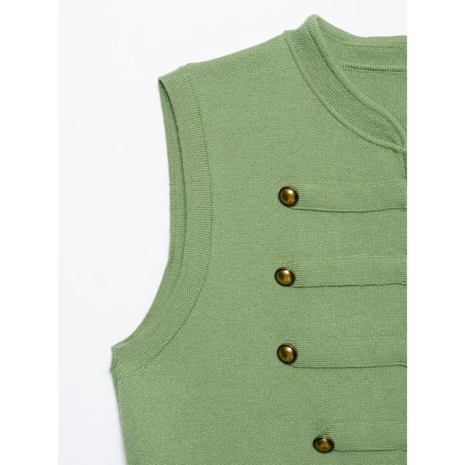 Close‑up of round stand collar, armhole trim and brass button details on green sleeveless knit waistcoat