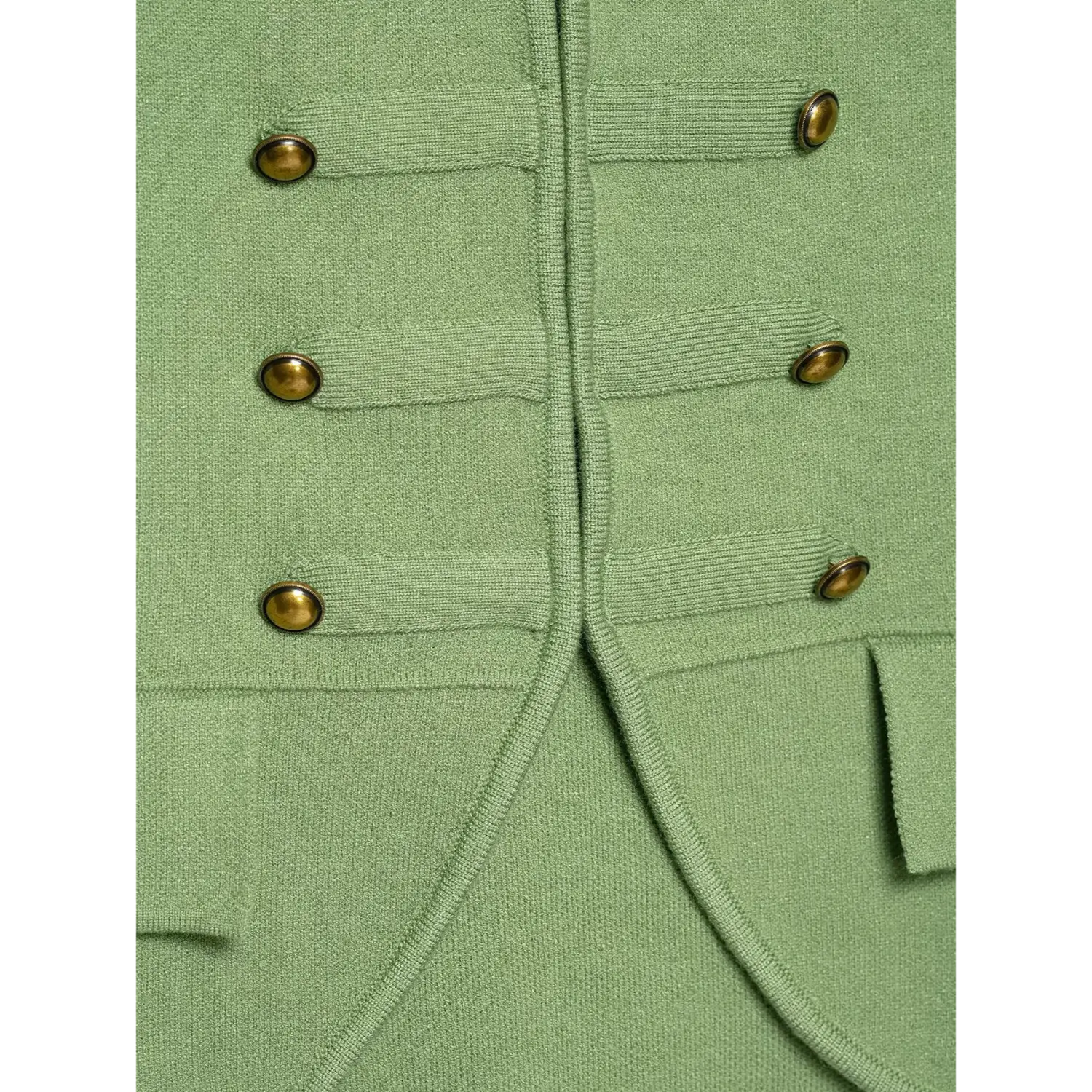 Macro close‑up of double‑row antique brass buttons and front pocket detail on sage green knit vest