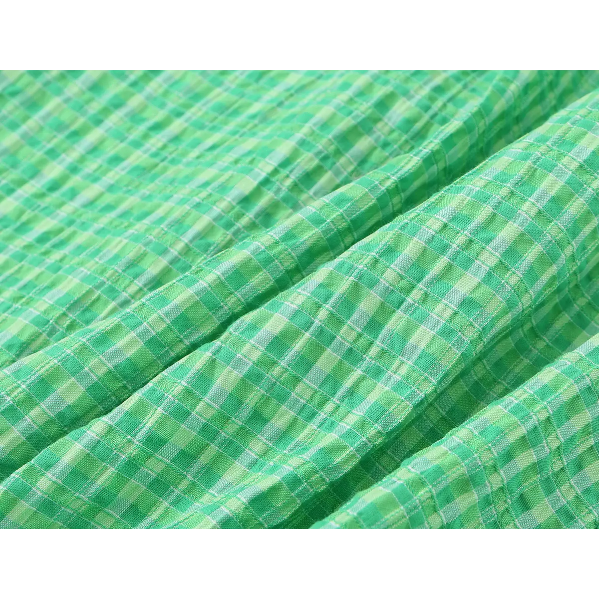 Close-up of the dress's crinkled gingham fabric, showcasing its unique texture and pattern details.