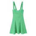 Front view of a bright green gingham sundress with smocked straps, sweetheart neckline, and A-line skirt.