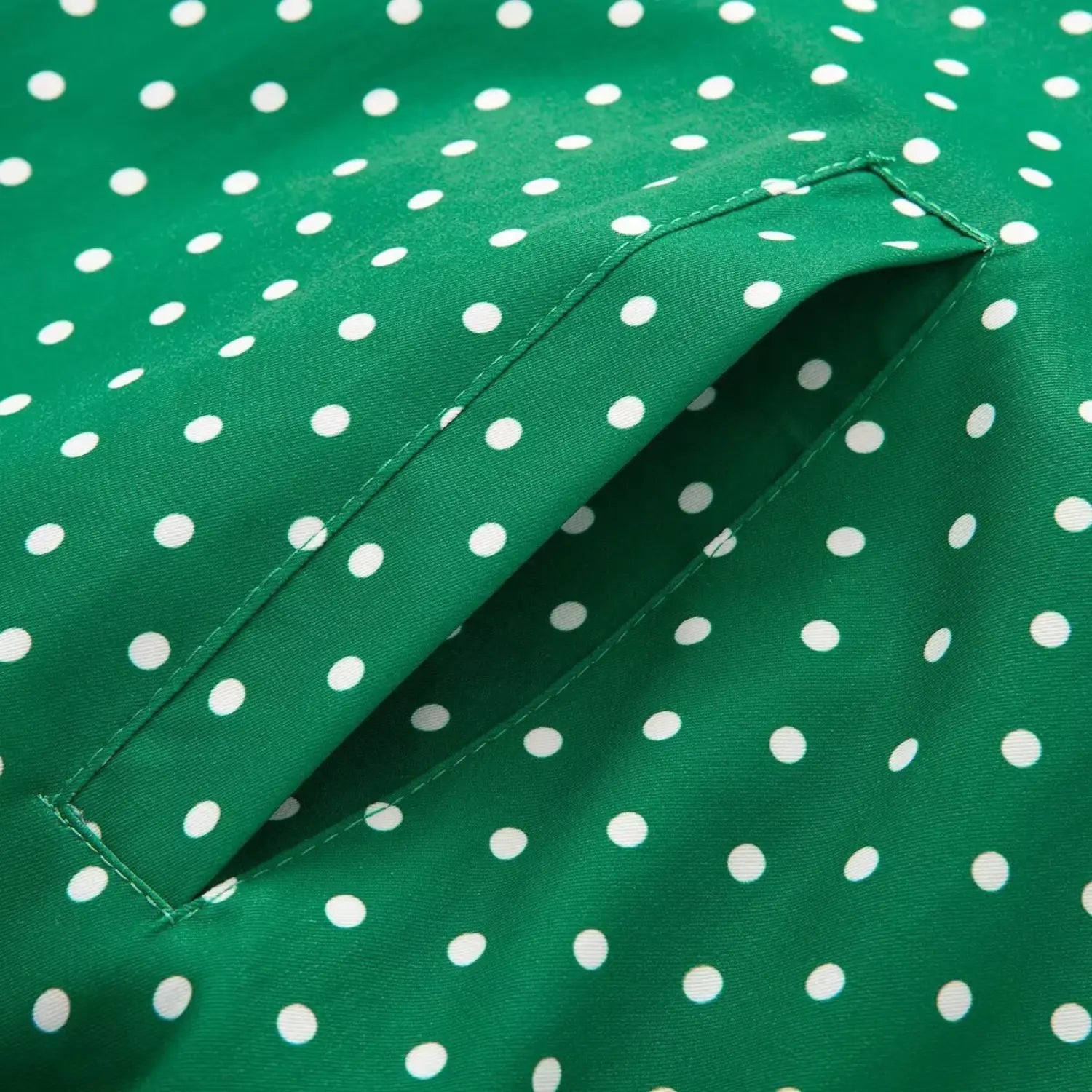 Side patch pocket stitching detail on green white polka dot outerwear