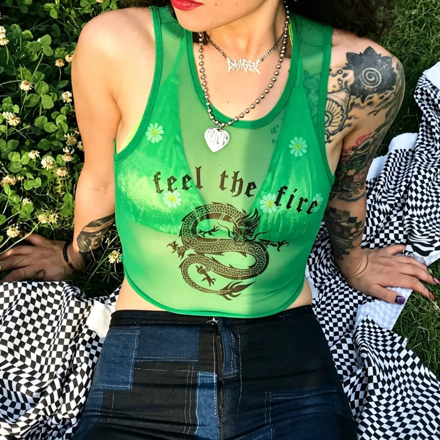 Outdoor sitting model close‑up front view green mesh sleeveless crop top with dragon and letter print