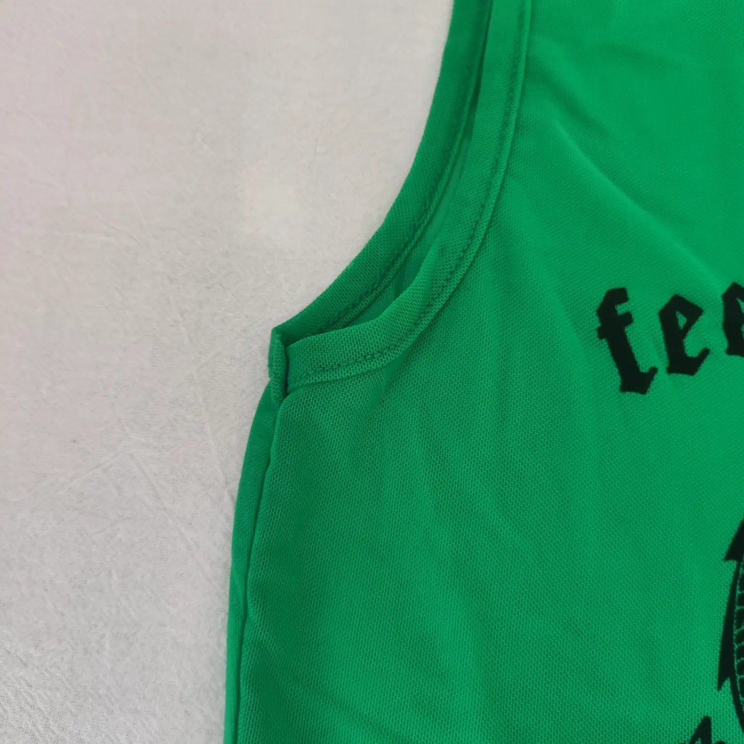 Close‑up armhole stitching and mesh fabric edge detail green round neck cropped tank top