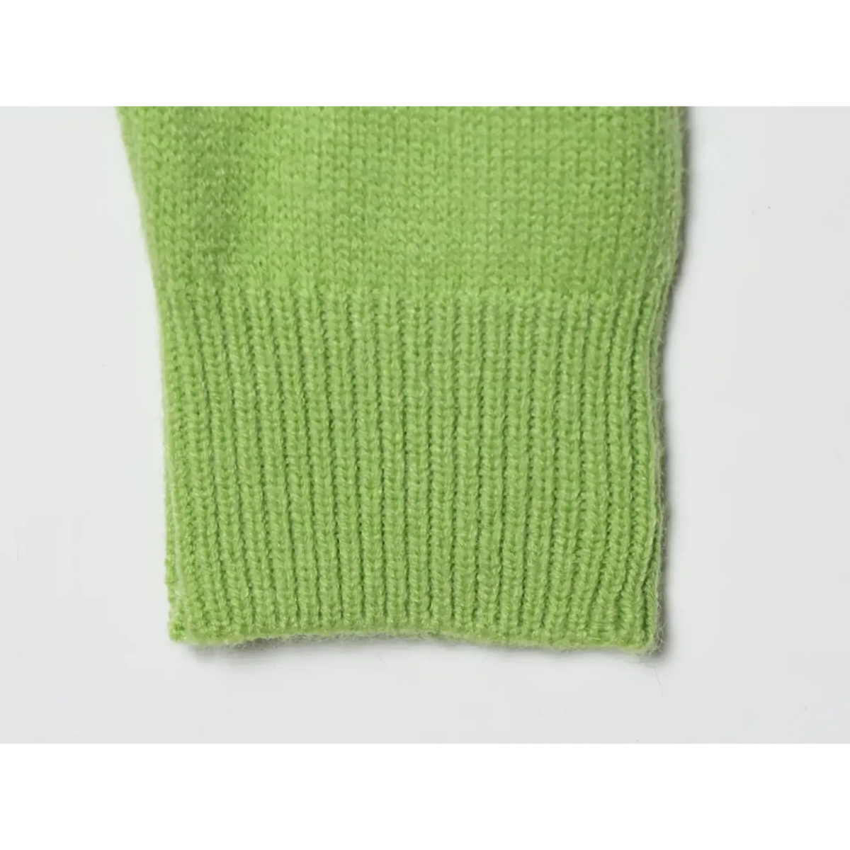 Close-up of vertical ribbed cuff on avocado green knit sweater
