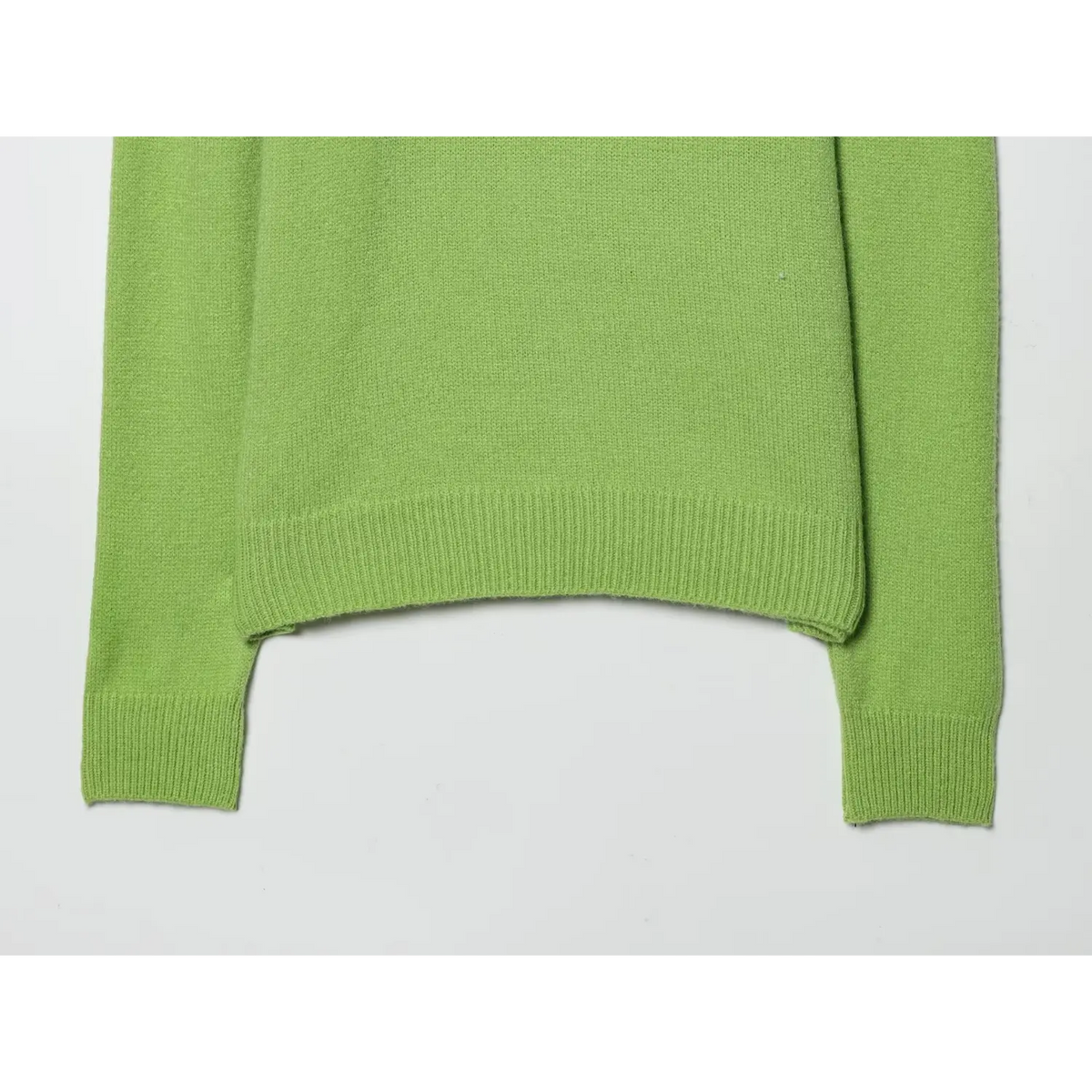 Close-up of ribbed hem and ribbed cuffs on green knit sweater