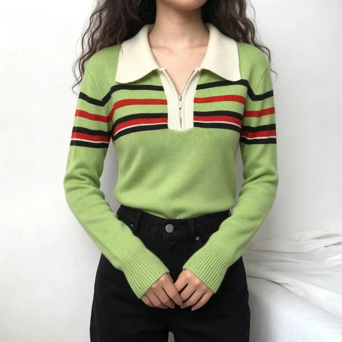 Model wearing green knit sweater with collar zip and stripe trims with black jeans