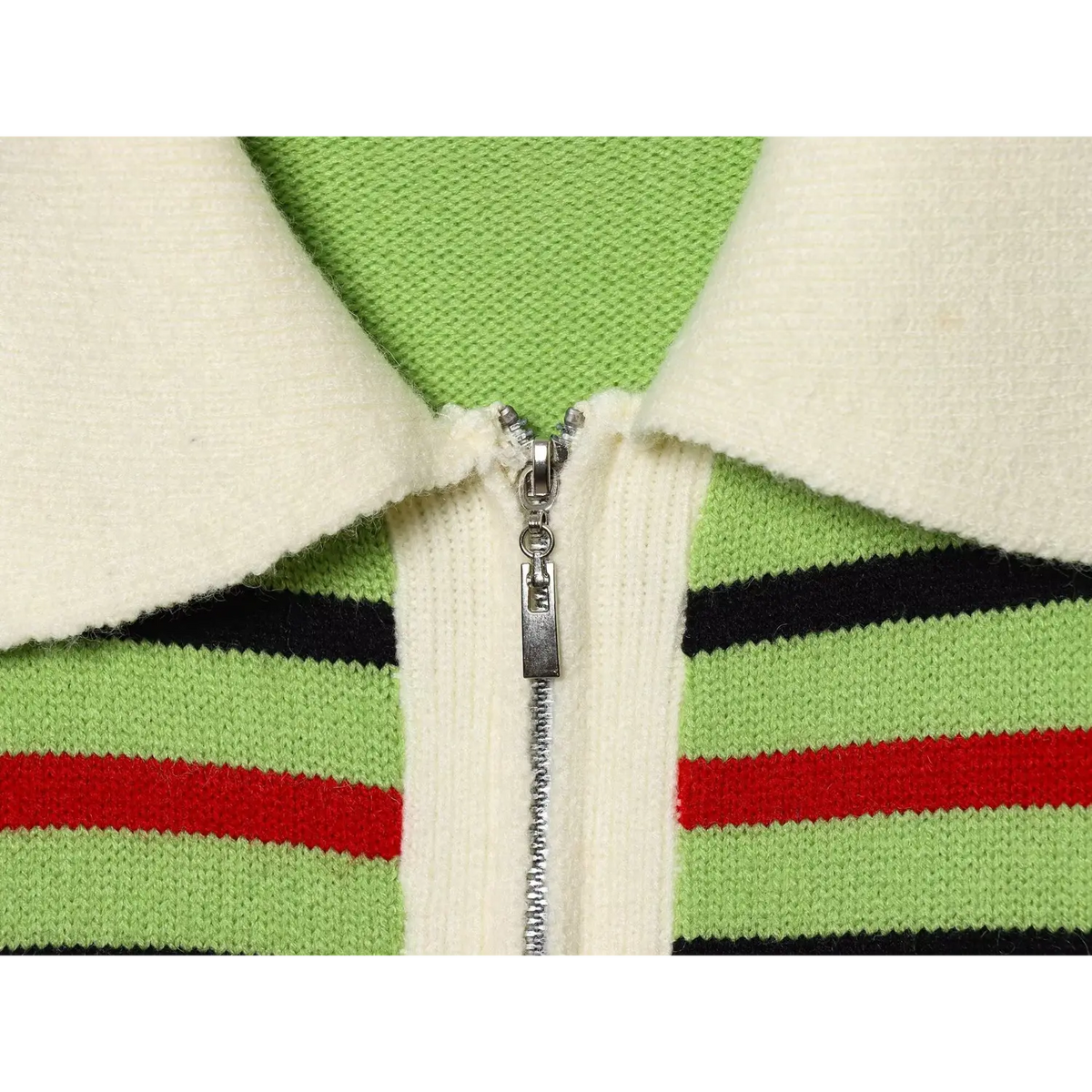 Close-up of silver zip placket with cream collar on green knit fabric with black and red stripes