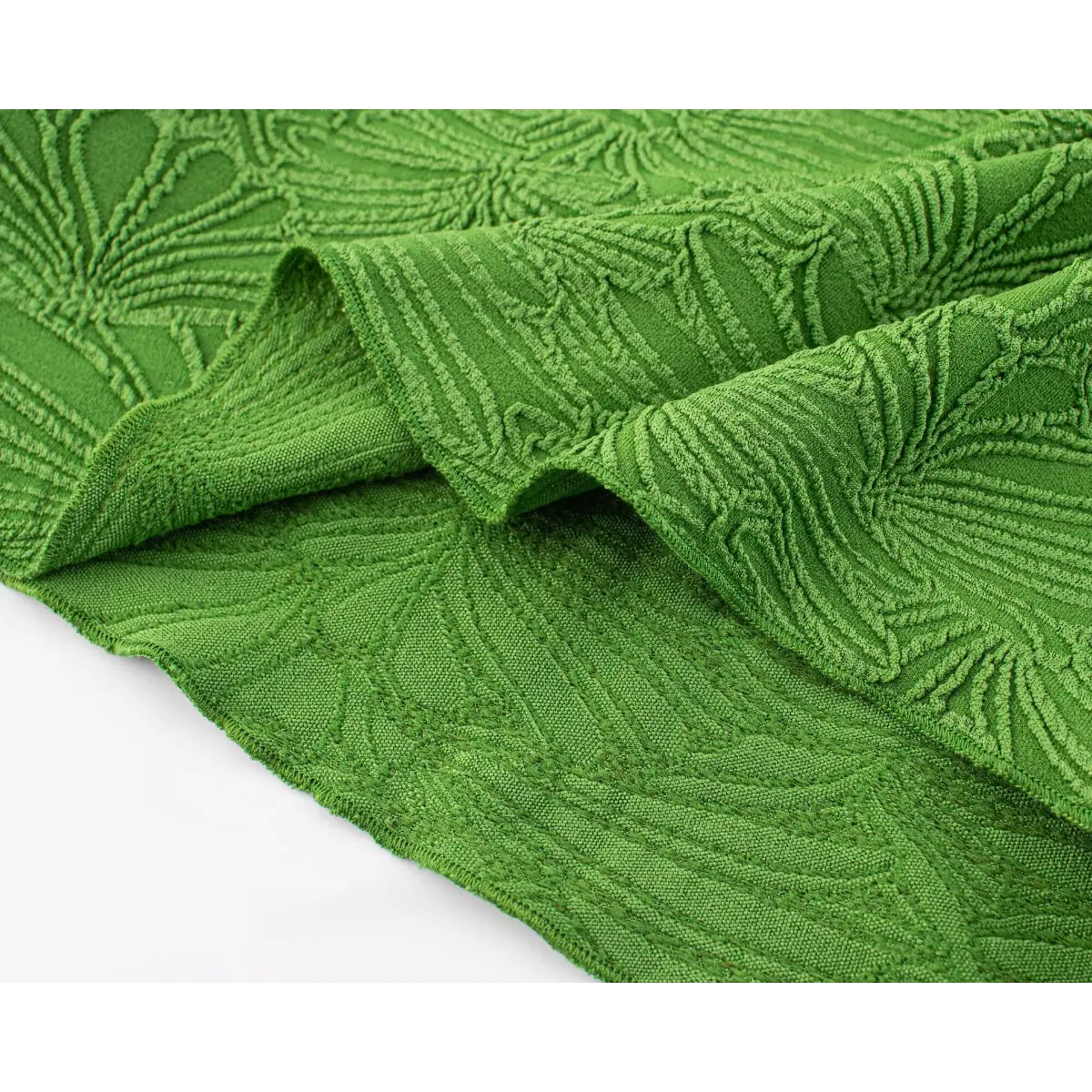 Close-up shot of green embossed leaf fabric, showing the raised texture, detailed leaf pattern, and soft drape.