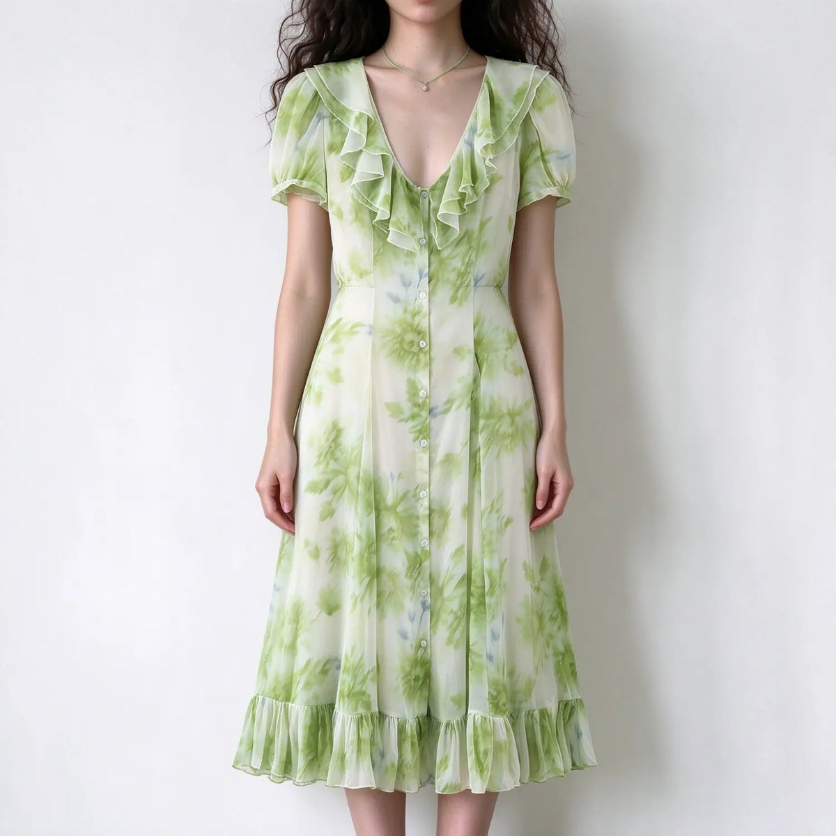 Model wearing green watercolor floral v-neck maxi dress with short puff sleeves and ruffle hem, white background