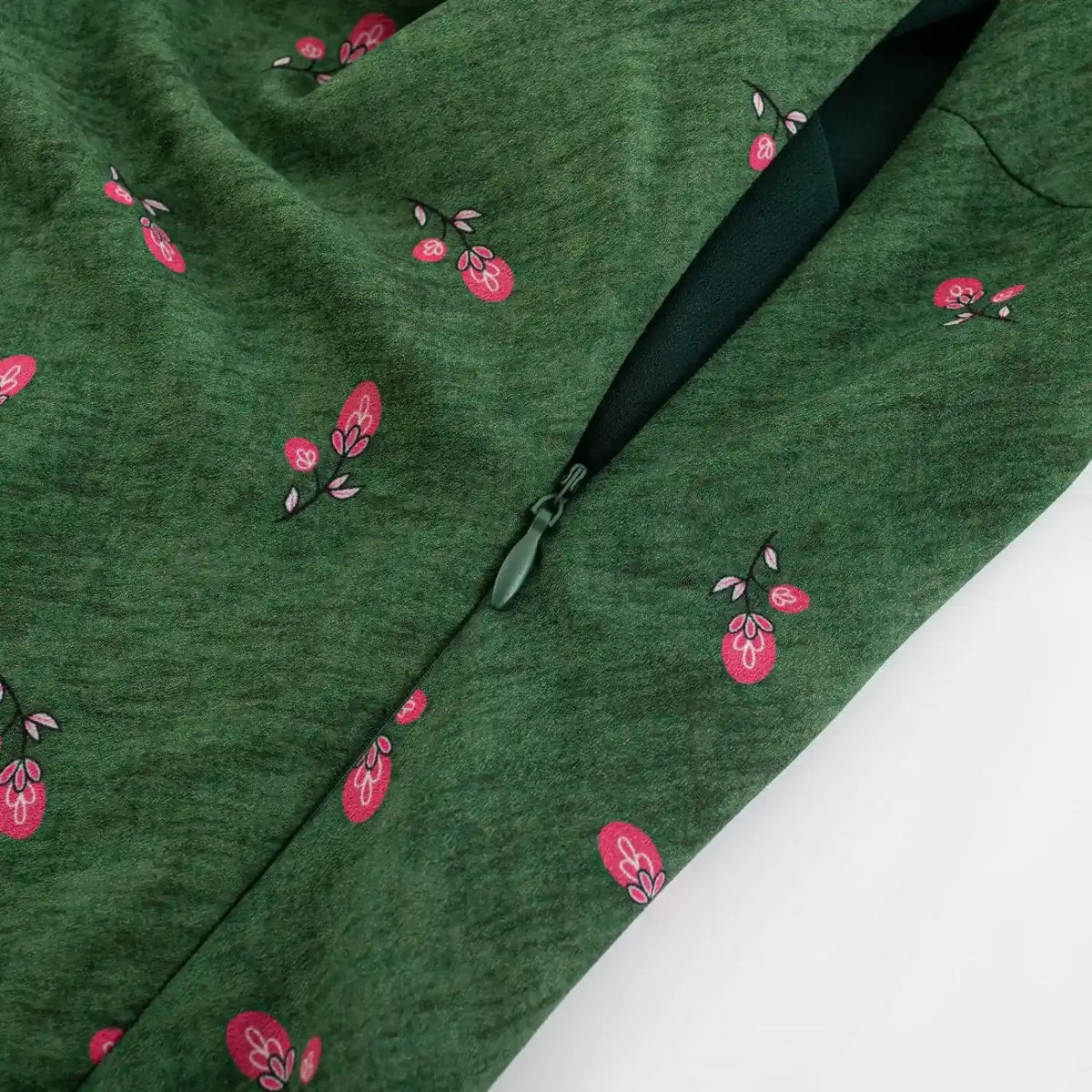 Partial close‑up of side zipper on green fruit print maxi dress