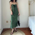 Model wearing green cami maxi dress with pink fruit print, front view