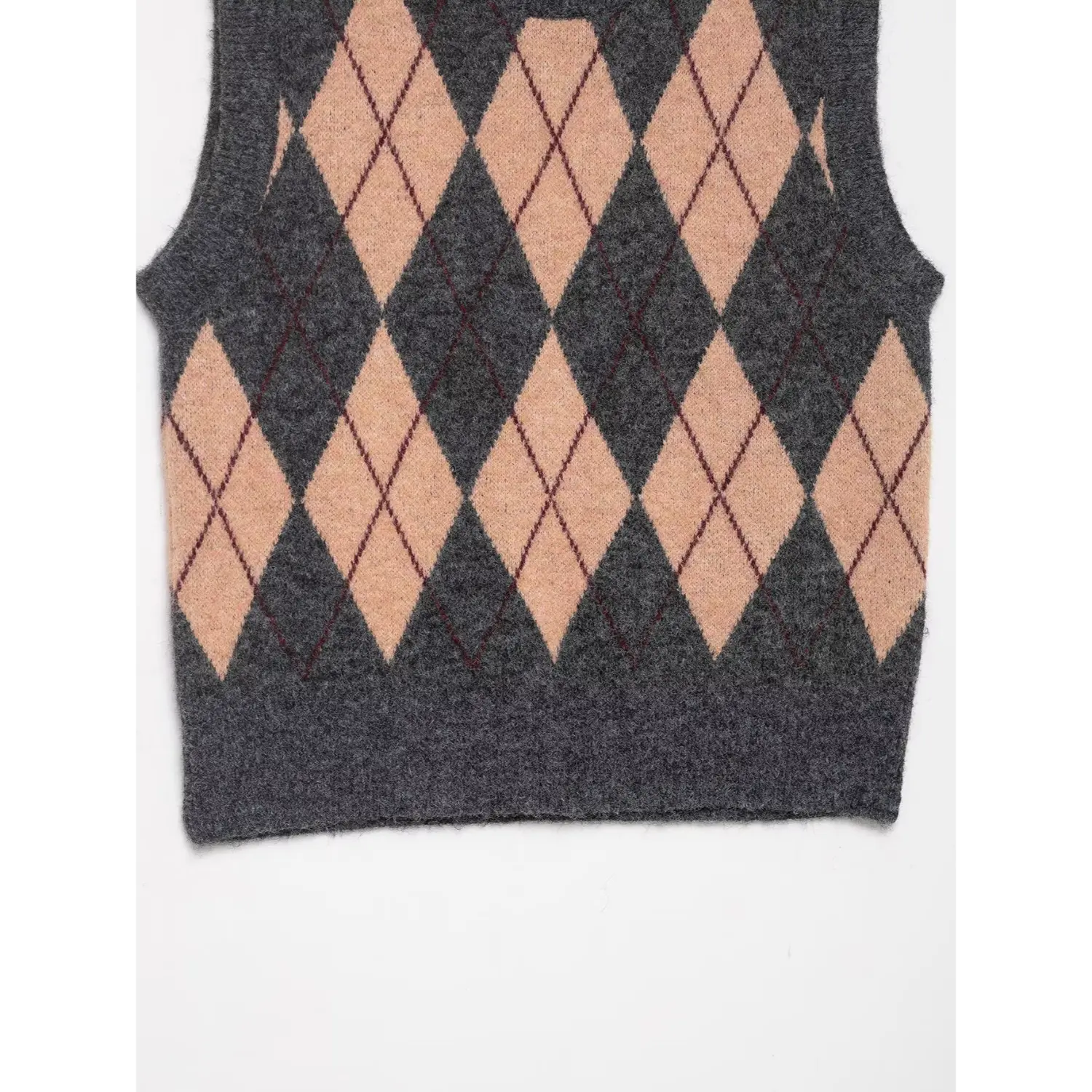 Close-up of the bottom hem and argyle pattern on grey knit vest