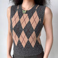 Lifestyle wearing shot of grey and beige argyle print knit vest, paired with bottoms