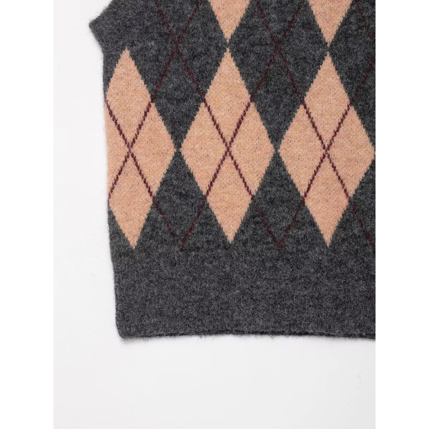 Close-up of the ribbed knit hem on the bottom edge of the argyle vest
