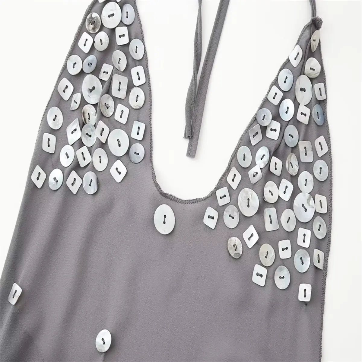 Front view of the grey chiffon halter dress, showing the deep V-neck, scattered shell buttons, and halter straps