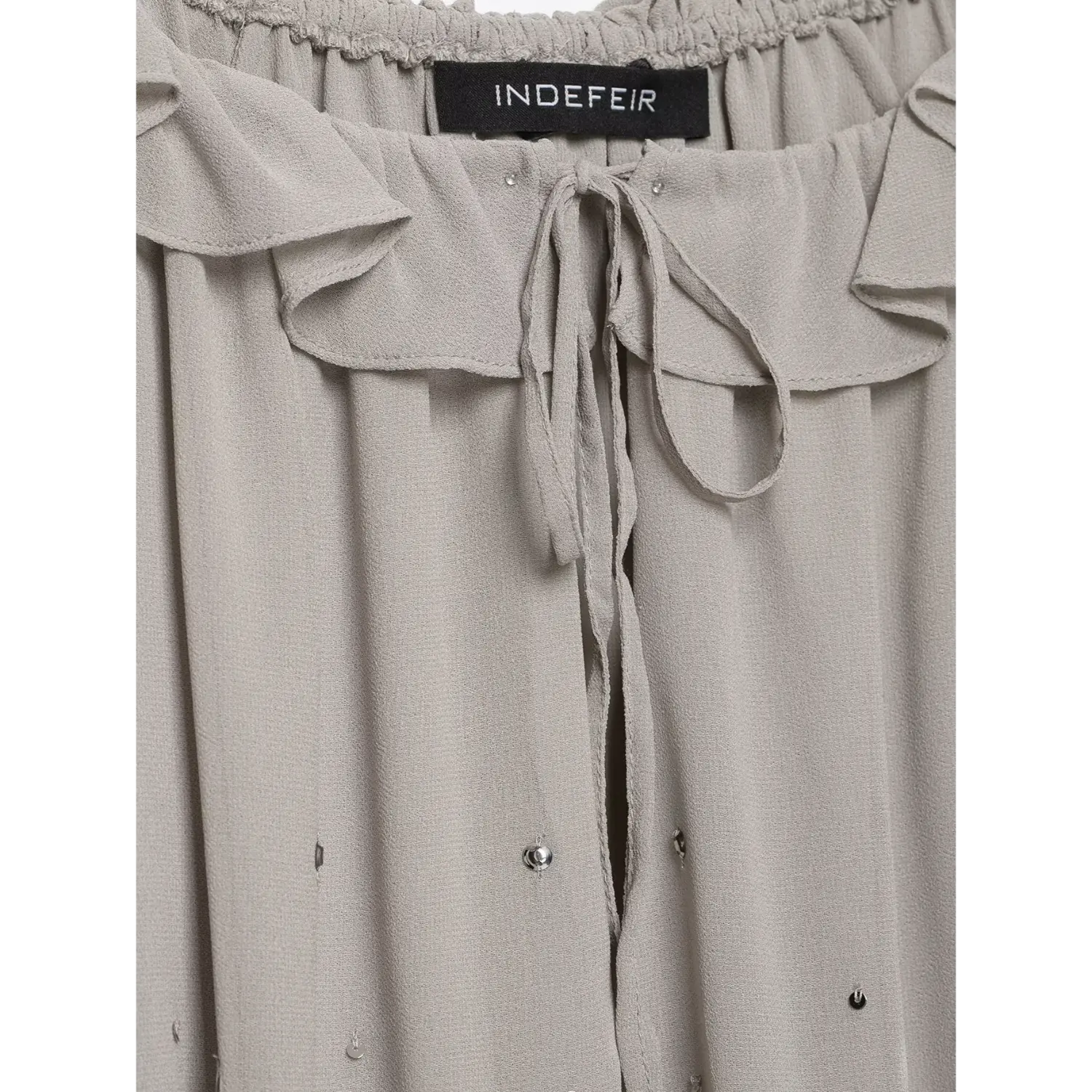 Close‑up view of ruffle neck drawstring tie and inner brand label, elastic gathered neck on grey sequin chiffon dress
