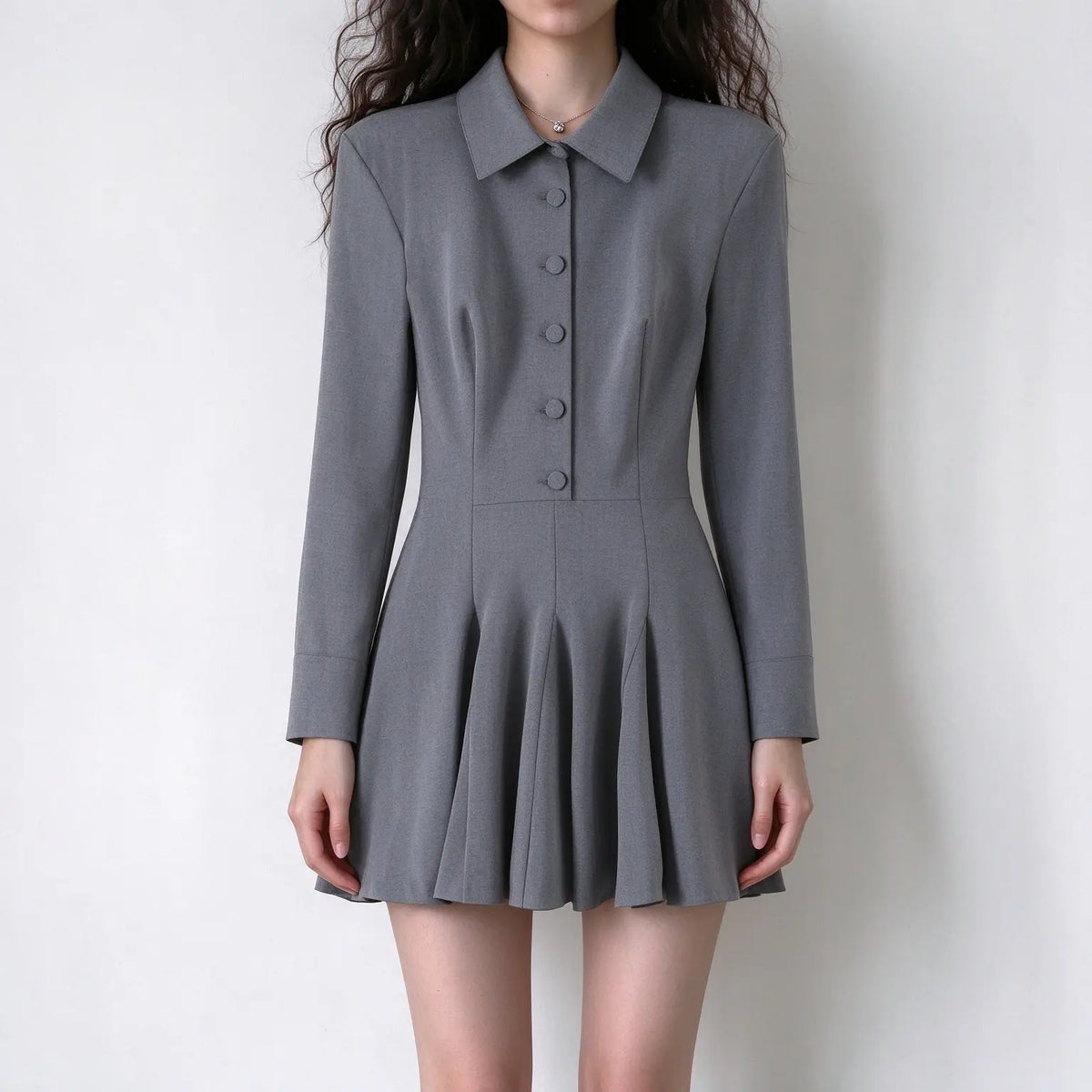 Model wearing grey collared button front pleated mini dress, front view