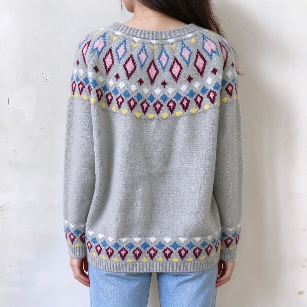 Female model back view, light grey fairisle knit sweater, colorful diamond jacquard pattern on yoke and cuffs, ribbed crew neck and hem, relaxed long sleeves