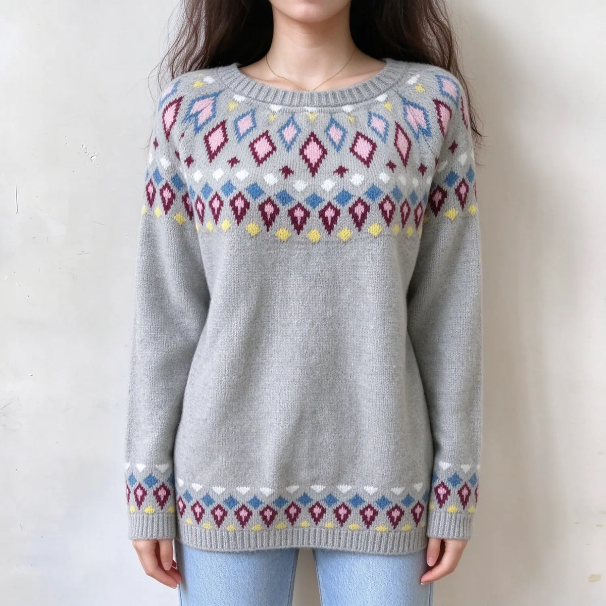 Female model wears light grey fairisle pullover, multi-colored diamond jacquard on yoke and sleeve cuffs, crew neck loose fit knit sweater, front torso shot