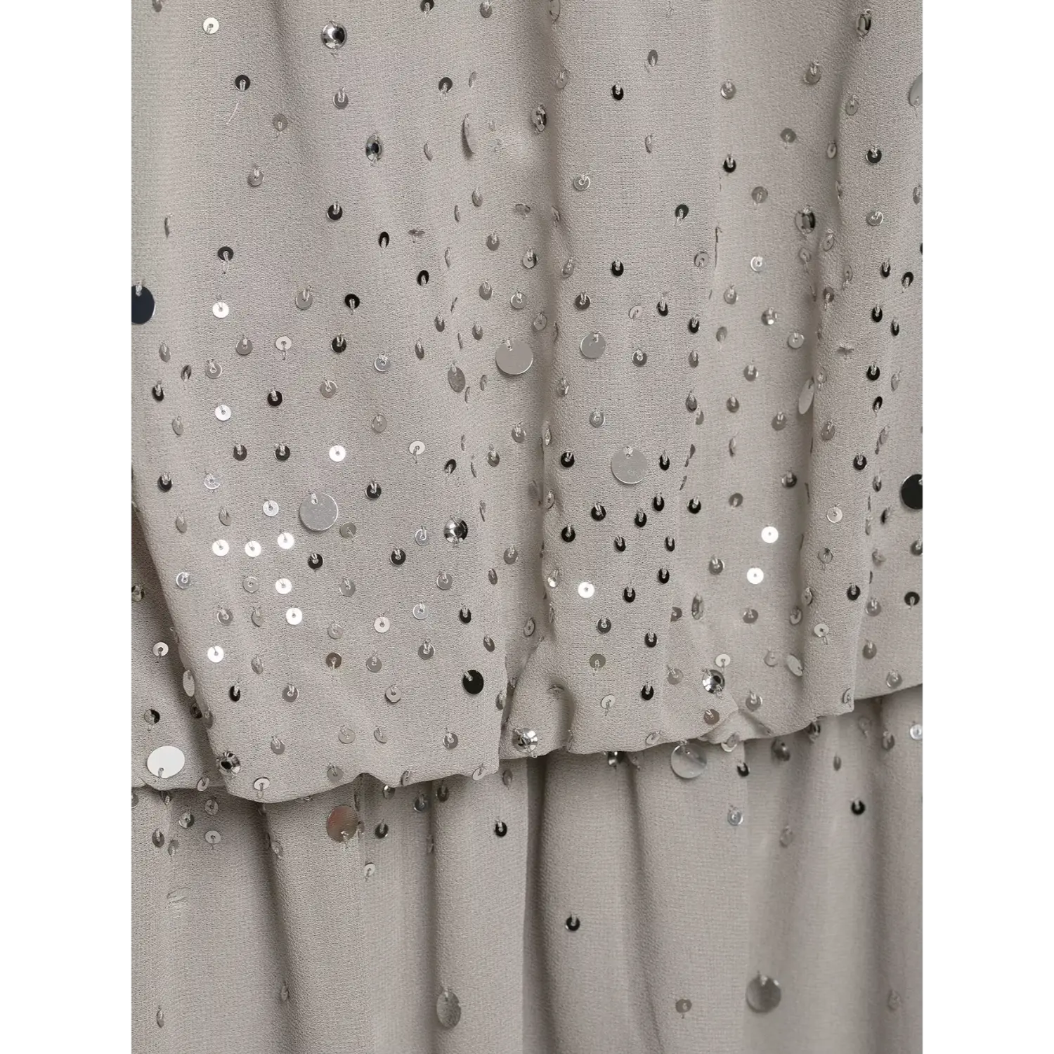 Macro fabric close‑up, ombre scattered silver sequins embellishment on soft grey lightweight chiffon material