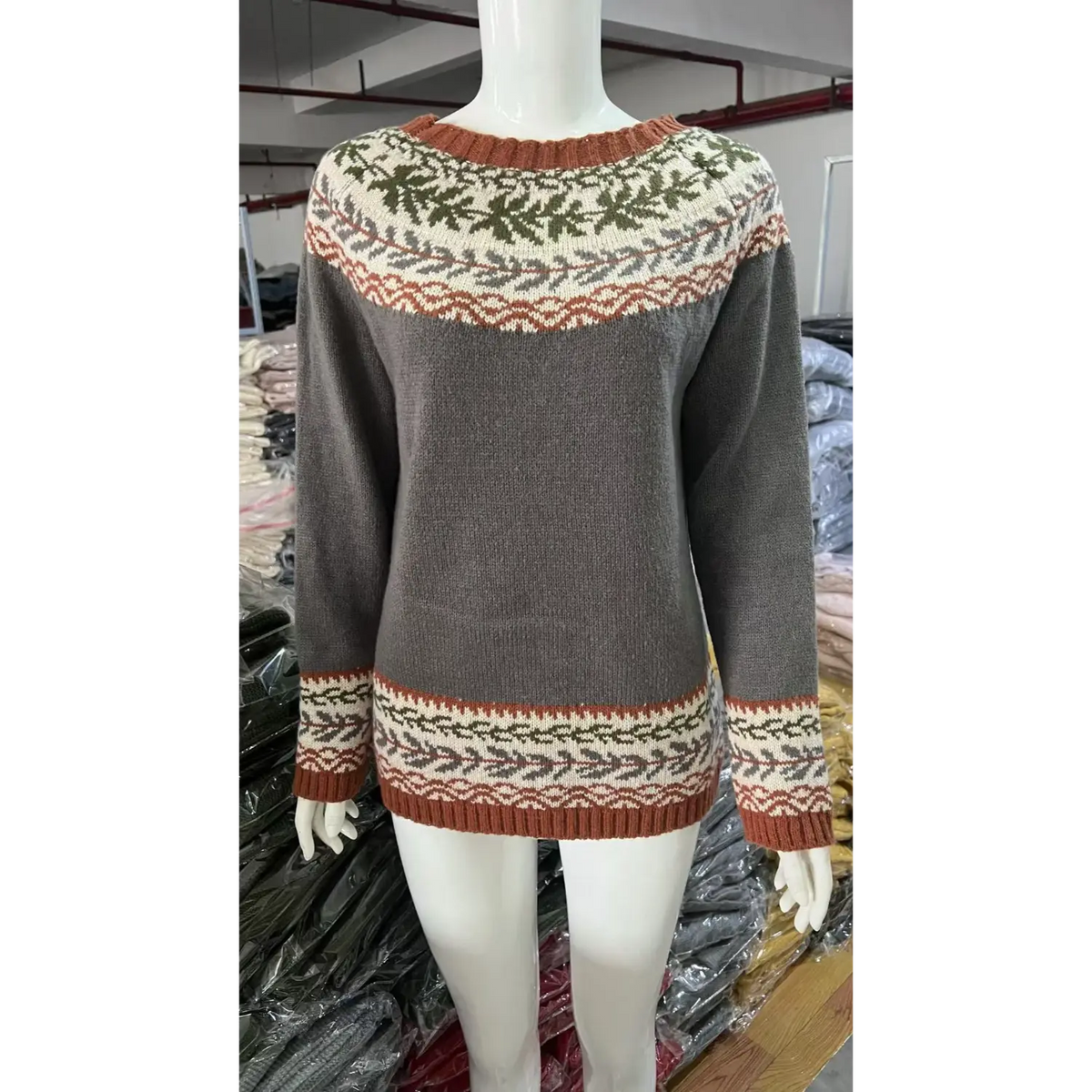 Front view of white mannequin in grey fairisle jacquard sweater, leaf motif knit pattern, factory storage background