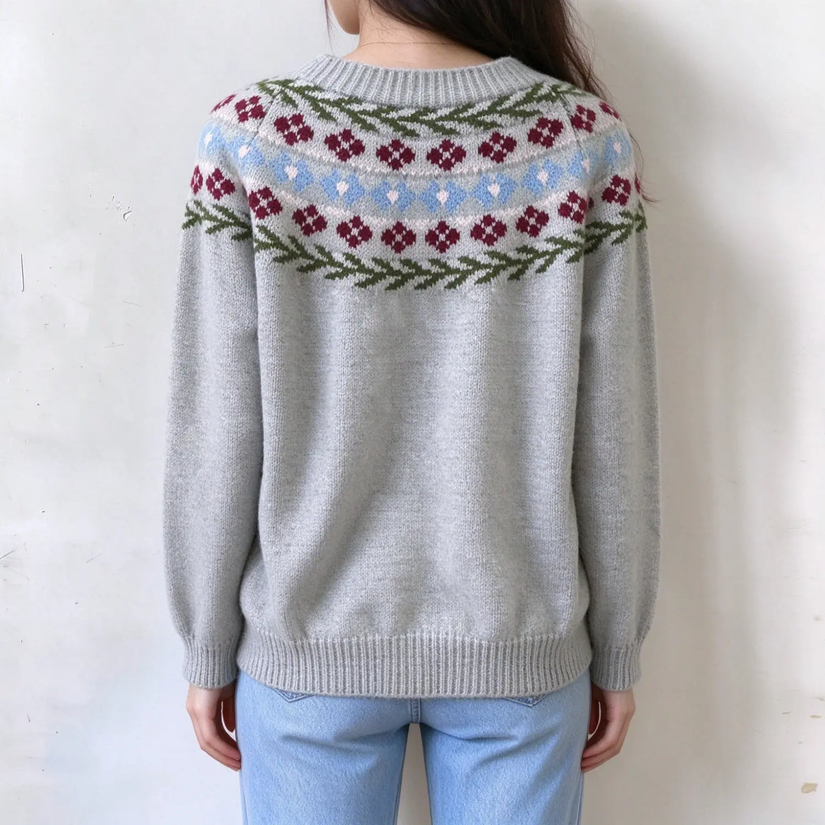 Female model back view, light grey fairisle sweater, red small flower and leaf jacquard yoke pattern, ribbed crew neck