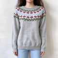 Female model wears light grey floral fairisle knit sweater, red flower and green leaf jacquard on yoke, relaxed crew neck pullover