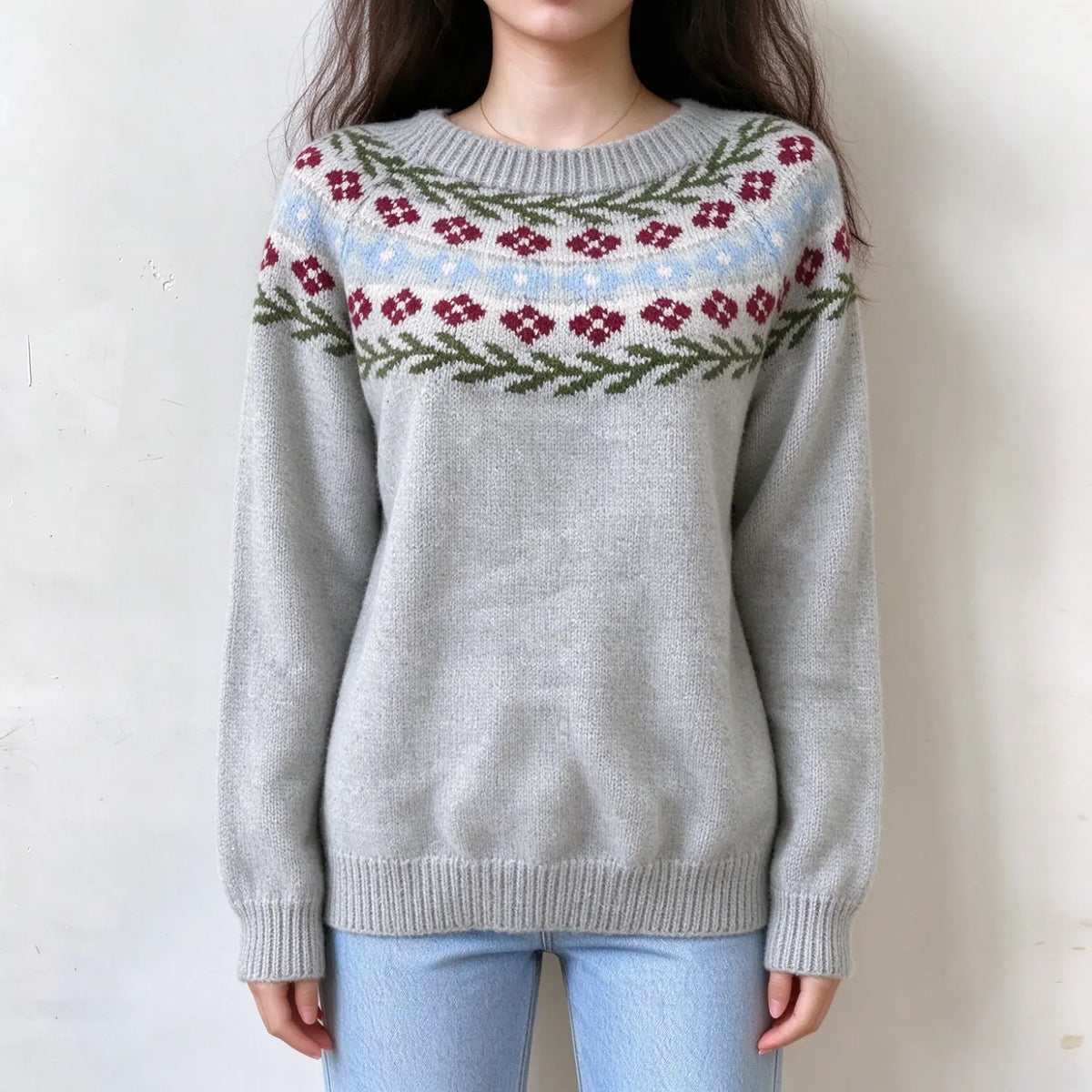 Female model wears light grey floral fairisle knit sweater, red flower and green leaf jacquard on yoke, relaxed crew neck pullover