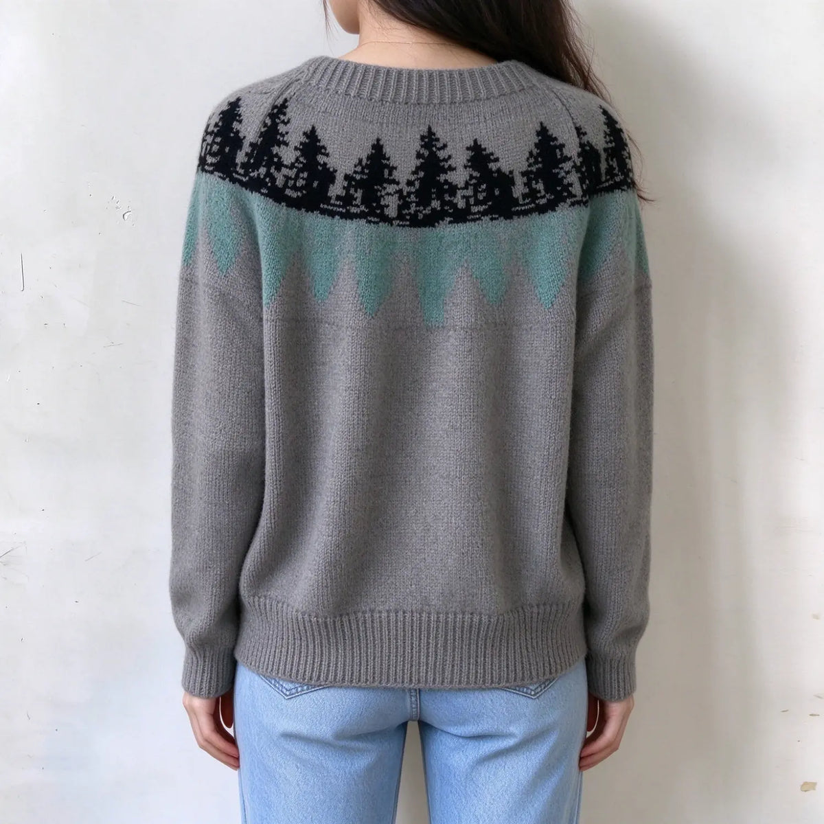 Female model back view, grey fairisle knit sweater, pine tree and mint geometric yoke pattern, ribbed crew neck and hem,