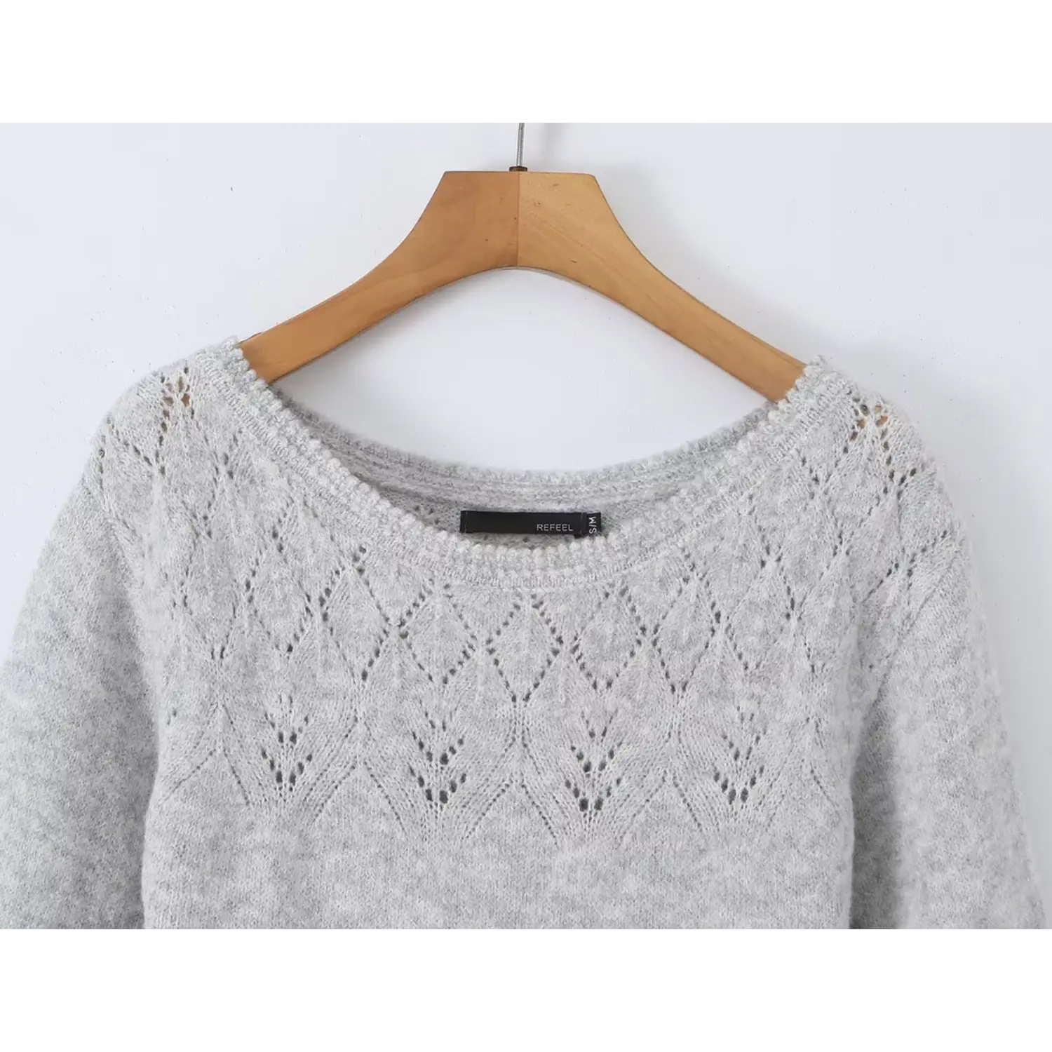 Close up macro detail of boat neck diamond hollow knit lace pattern on heather grey soft sweater dress