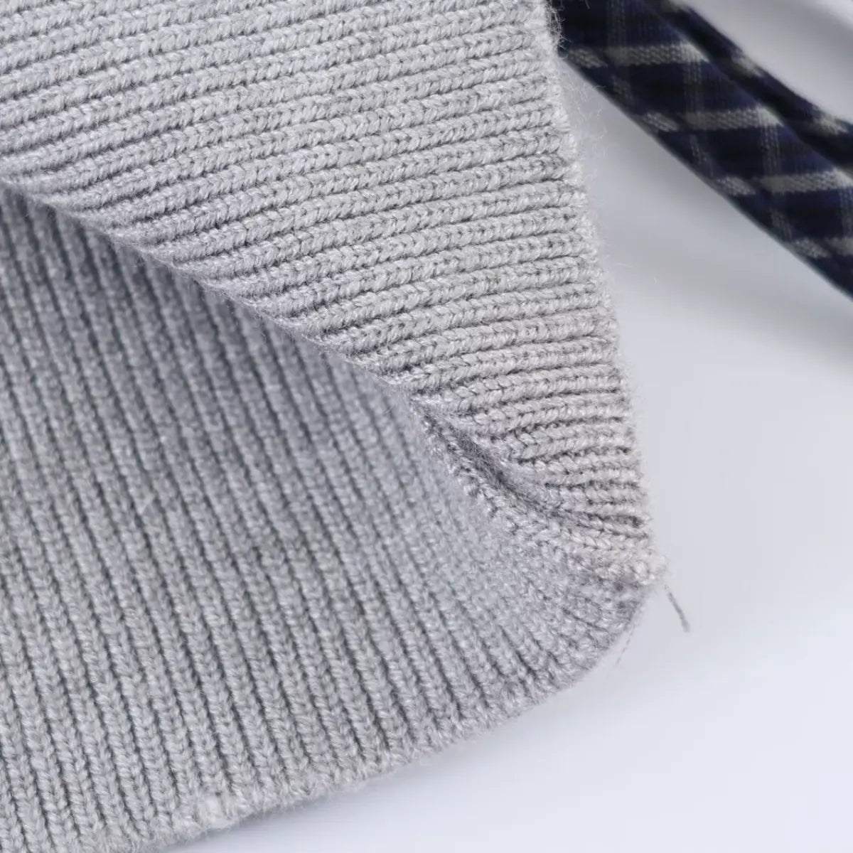 Grey ribbed knit fabric close-up, showing texture and edge finish