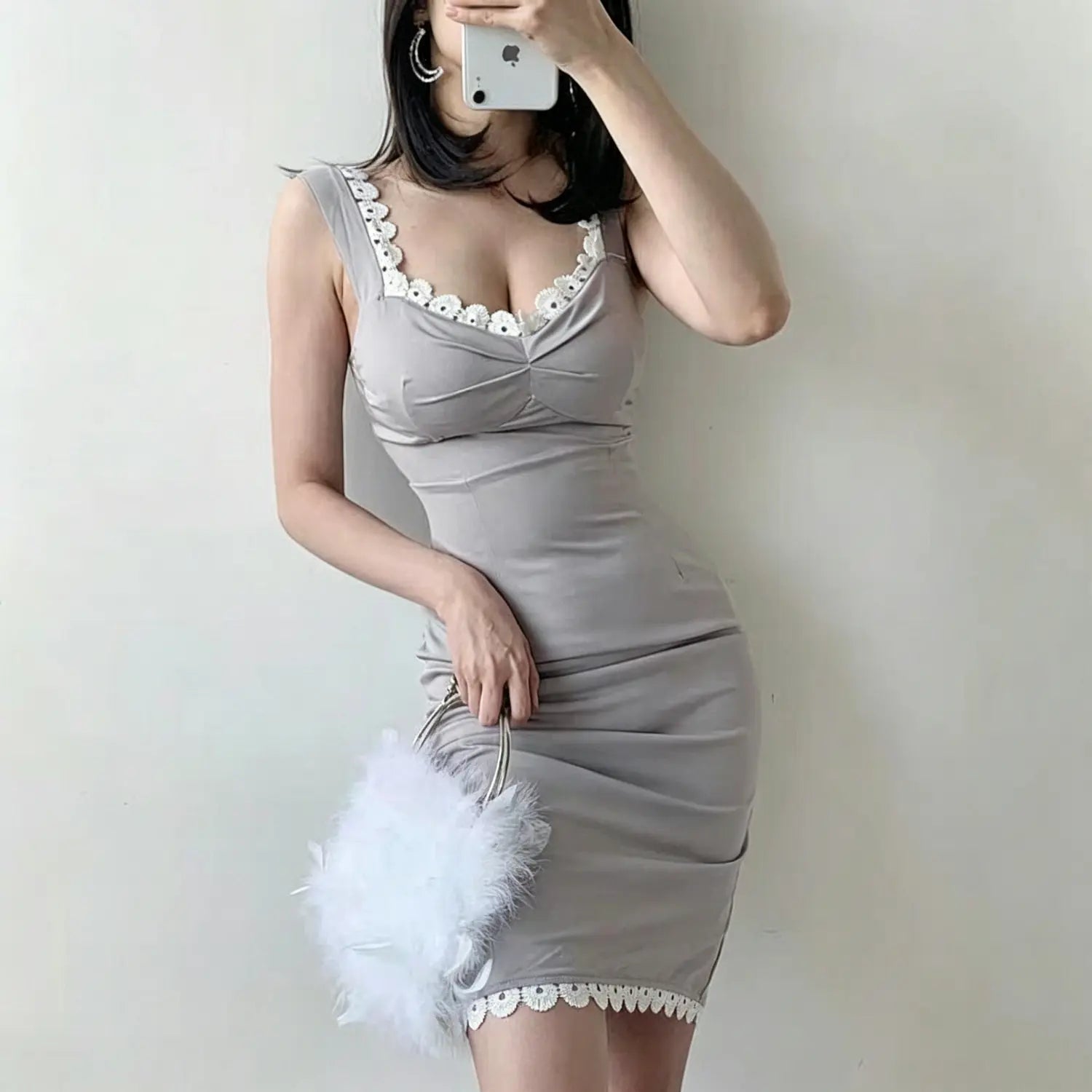 Model side pose grey fitted midi dress with white floral lace on neckline and hem