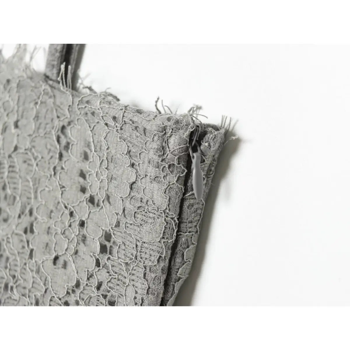 Close-up of the side zipper on the grey cami dress, showing the matching grey pull and intricate lace pattern